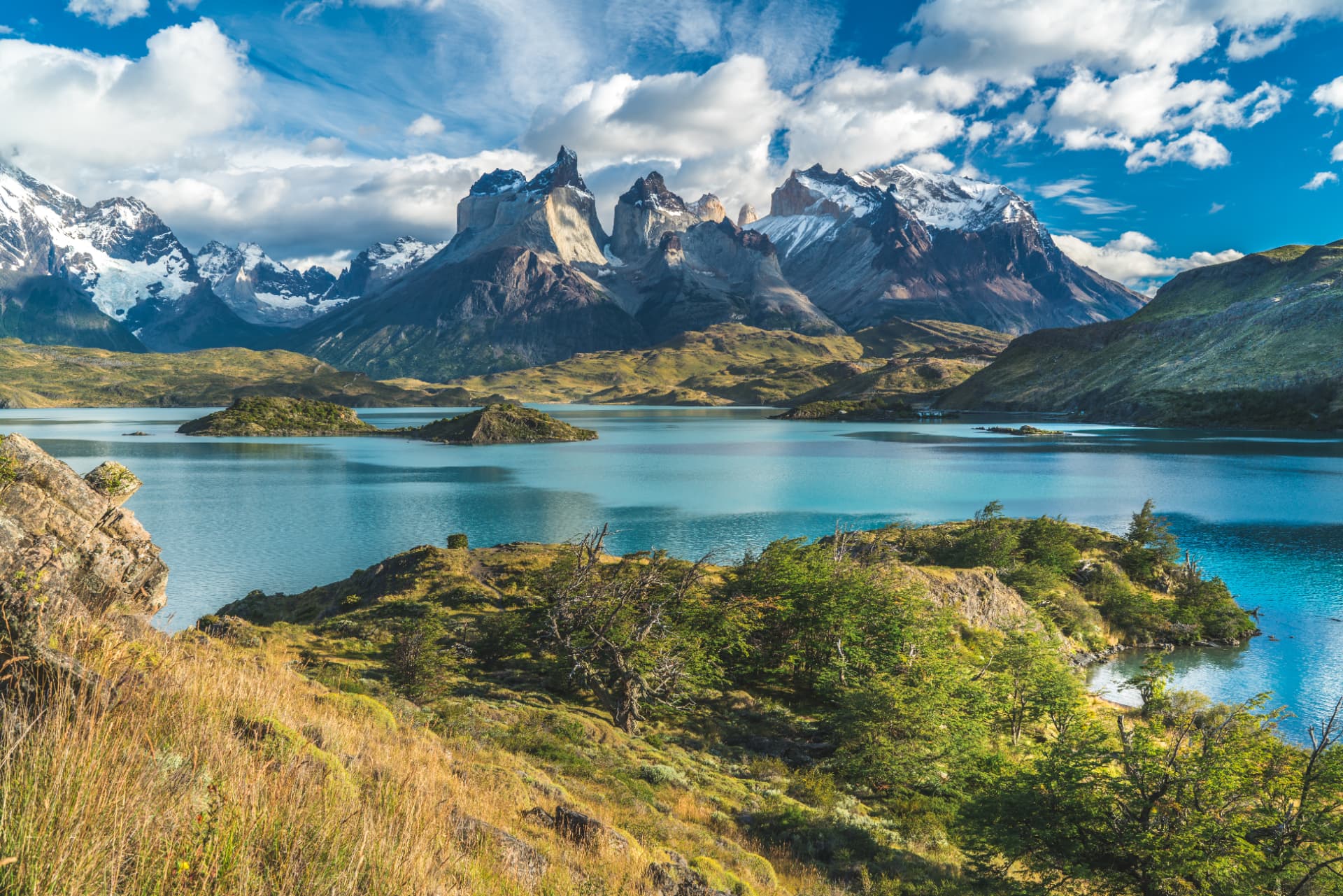 Torres del Paine peaks rising above a turquoise glacial lake under a wide Patagonian sky